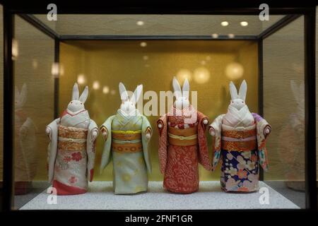 Four little toy rabbits dressed with Japanese dresses in a store front in Tokyo, Japan Stock Photo