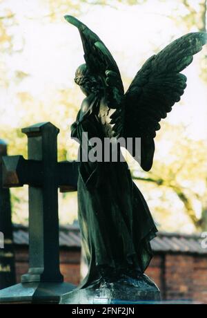 A cemetery figure and a cross at a cemetery in Munich. [automated translation] Stock Photo
