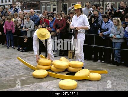 The tourist attraction of Alkmaar: the cheese market on the market square in Alkmaar. Two traditionally dressed runners with the cheese boards. [automated translation] Stock Photo