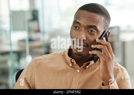 Young African businessman talking on his cellphone at work Stock Photo