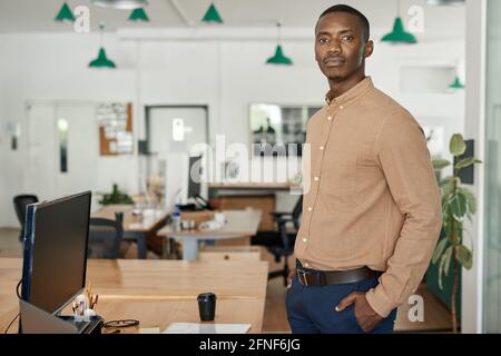 Confident young African businessman standing alone in an office Stock Photo