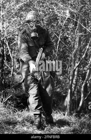 A soldier of the German Federal Armed Forces during an exercise with an NBC protection mask on. The soldier is armed with a G3 A4. NBC defence stands for protection against nuclear, biological and chemical warfare agents. [automated translation] Stock Photo