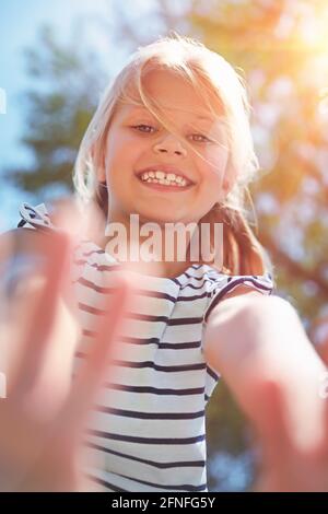 Closeup Portrait of a Cute Little Girl with a Big Toothy Smile. Having Fun Outdoors in Sunny Day. Enjoying Summer Holidays. Carefree Childhood. Stock Photo