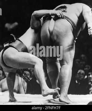 Two sumo wrestlers during a match in Osaka, Japan. One of them grabbed the other by his belt. [automated translation] Stock Photo