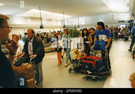 Travelers in the baggage hall of the airport on Lanzarote. After landing, holidaymakers wait at the baggage conveyors. [automated translation] Stock Photo