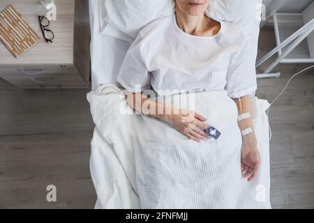 High angle view of sick patient lying on bed and recovering after operation at hospital Stock Photo