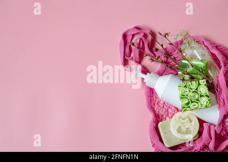 Flat lay spa composition with personal hygiene items and bath accessories in a string bag. Stock Photo