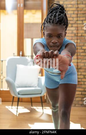 Side view of fit black athlete exercising during training in living room at home Stock Photo