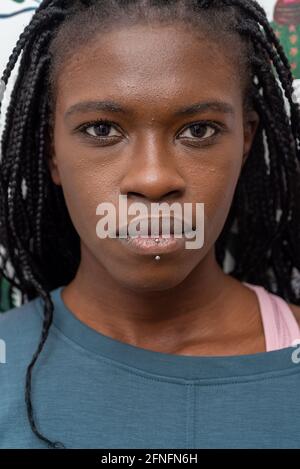Headshot of determined African American female with black braids and piercing looking at camera Stock Photo