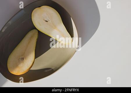 Modern minimal still life, pears on a plate in natural light. Stock Photo