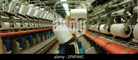 Saxony-Anhalt / Industry / GDR / Leuna 1995. The DOMO Group (carpets) has built a new plant for the production of carpet fibres. The photo shows the spinning mill. The yarns are wound on the yarn reels. The women have to put in new rolls, thread the yarn and grab it if it breaks down. Typical women's work. The factory was built on the old VEB site, which is now home to many companies. Successfully privatized by the Treuhand // Saxony-Anhalt / Economy / Women / Textile / In 1916, BASF from Ludwigshafen builds an ammonia factory near the village of Leuna. In 1924 a methanol plant is added and Stock Photo