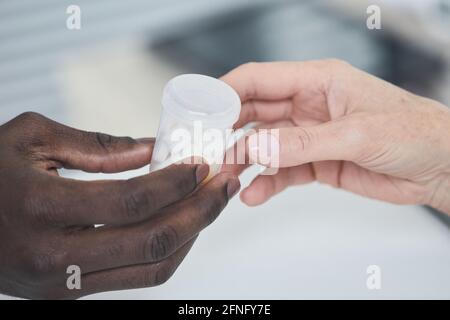 Close-up of African man giving bottle with medicine to woman Stock Photo