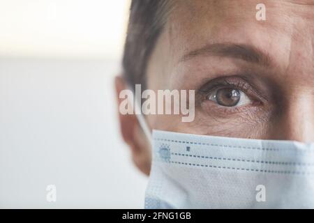 Close-up of mature woman's face in protective mask Stock Photo
