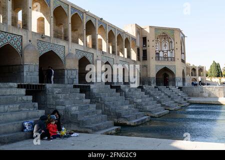 Picknicking family on he historic Khaju bridge over the Zayanderud river in Isfahan, Iran Stock Photo
