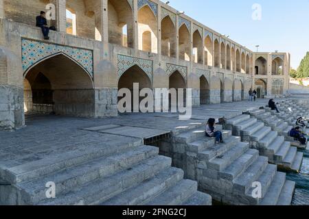 Relaxing people on the historic Khaju bridge over the Zayanderud river in Isfahan, Iran Stock Photo