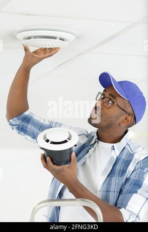 man installing ventilation grill in ceiling Stock Photo