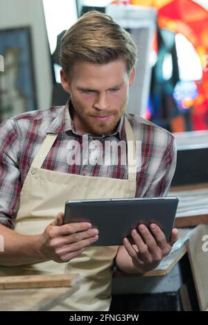 man using digital tablet in workshop Stock Photo