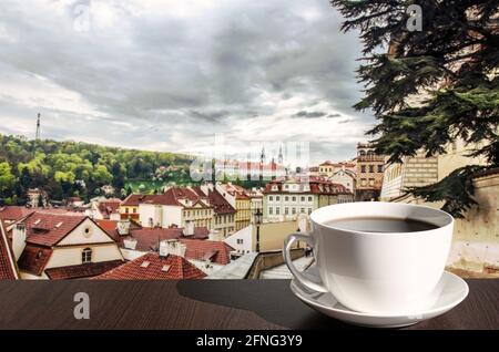 Cup of hot black coffee in cafe with view of street in Prague, Czech Republic. Street with beautiful view on historic downtown in Prague. Stock Photo