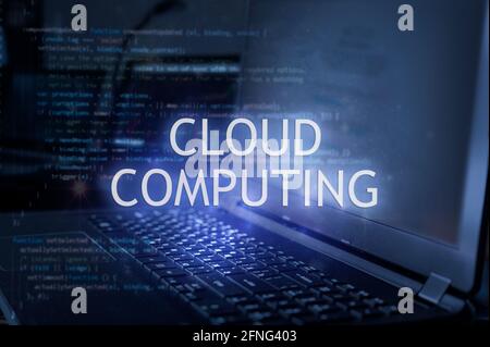 Cloud computing inscription against laptop and code background. Technology concept. Stock Photo