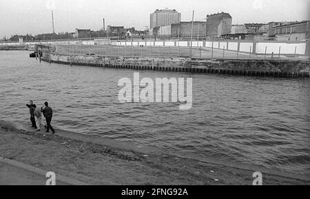 GDR, Berlin, 23.02.1990, Spreebogen, view over the Spree to the wall on the east side, Charité high-rise building, people on the bank, [automated translation] Stock Photo