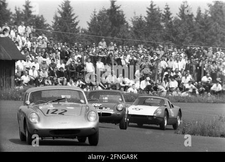1000km race on the Nürburgring 31.05.1964. In front an Austin Healey Sebring Sprite (No. 122) , MG Midget (No. 118) and a Porsche 904 GTS (No. 65). In the background many spectators , separated only by a fence. [automated translation] Stock Photo