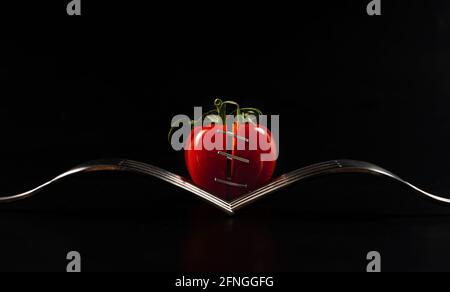 Cherry tomato in between two forks Stock Photo