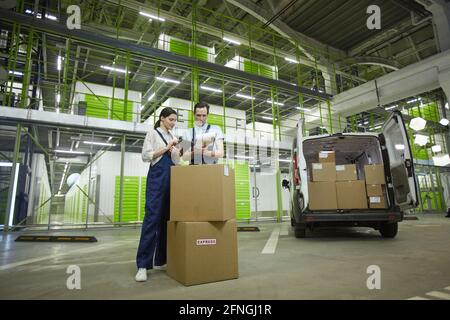 Two people packing parcels in boxes while working in delivery service Stock Photo