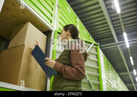Young woman checking the boxes and packing them in storage Stock Photo