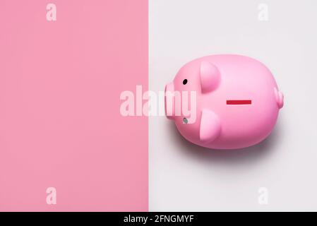top view of pink piggy money bank  with copy space on a pink and white background Stock Photo