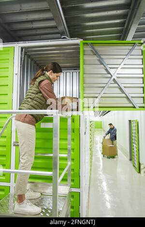 Young woman working in warehouse she packing parcels in storage box Stock Photo