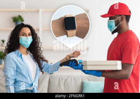 Black delivery man holding pizza box and pos terminal Stock Photo