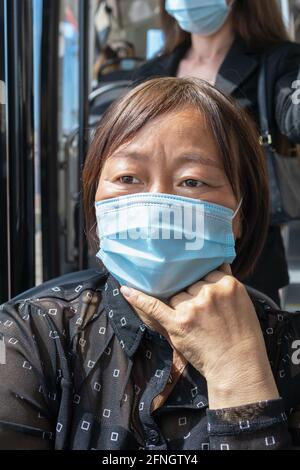 Mature asian woman wearing a mask on a bus: Selective focus. Safety and new public transport rules concept. Stock Photo