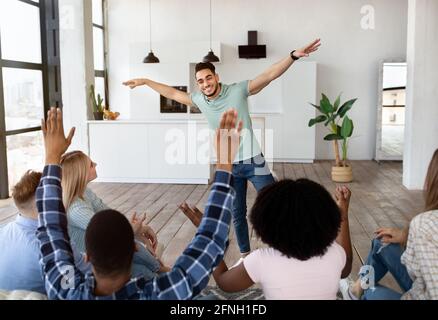 Funny young diverse friends playing guess who game, laughing, having fun together at home Stock Photo