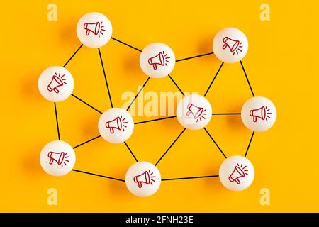 Balls with megaphone icons linked to each other representing a network. Online communication, social networking or information sharing concept. Stock Photo