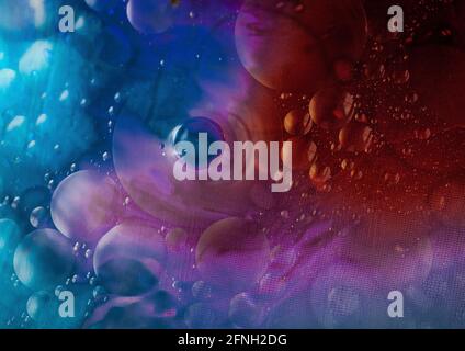 Oil and water agitated to make bubbles with light shining through the liquids Stock Photo