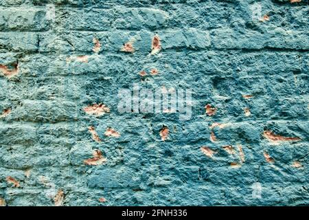 Worn brick wall painted aqua with orange highlights and interesting texture for backgrounds Stock Photo