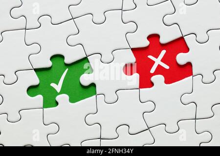 Missing puzzle pieces with check mark and cross symbols. Approve or reject, right or wrong, yes or no in decision making, education or voting concept. Stock Photo