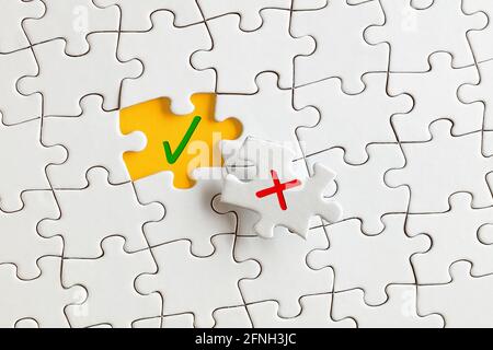 Check mark (right) and cross mark (wrong) on the missing puzzle pieces. To discover or expose the right or truth concept. Stock Photo