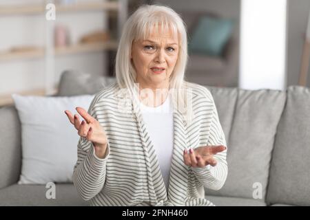 Mature woman talking at camera and gesturing Stock Photo