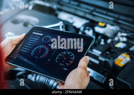 car engine diagnostics. service mechanic using digital tablet to inspect vehicle condition Stock Photo