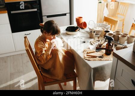 6 years old girl planting herbs at home Stock Photo