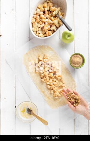 Adding nuts in the apple strudel filling Stock Photo