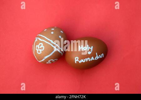 Holy Ramadan hand typography on the egg. Red isolated background. Stock Photo