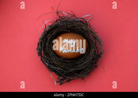 Holy Ramadan hand typography on the egg. Red isolated background. Stock Photo