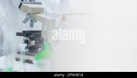 Composition of female scientist in lab using microscope with motion blur Stock Photo