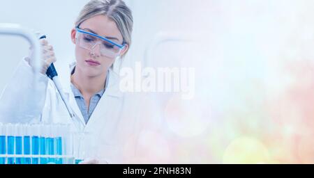 Composition of female scientist in lab using pipette and test tubes with motion blur Stock Photo