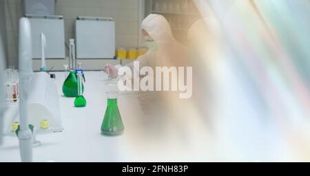 Composition of group of scientists in lab using pipette and test tubes with motion blur Stock Photo