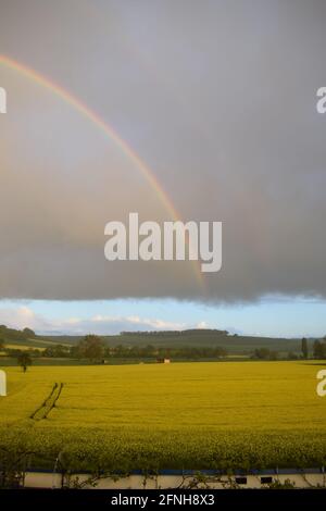 huge rainbow in front of dark clouds Stock Photo