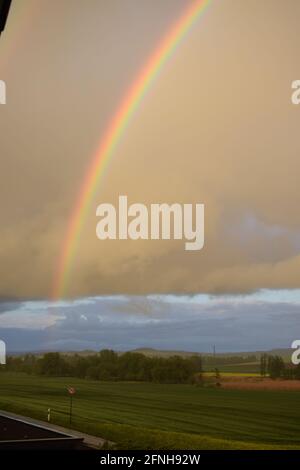 huge rainbow in front of dark clouds Stock Photo