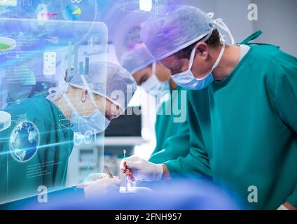 Composition of medical data processing on screen over surgeons in operating theatre Stock Photo